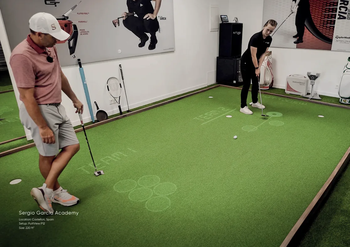 Dos golfistas practican sobre un green con objetivos y líneas proyectados.